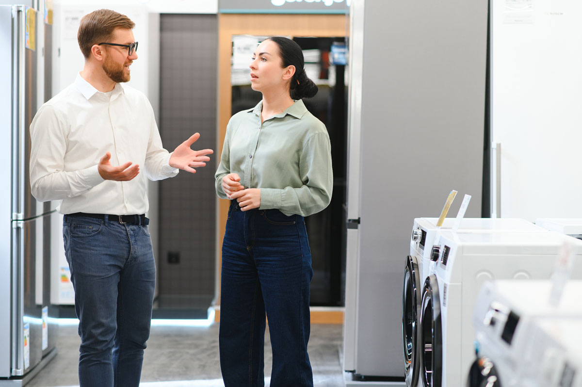 Beratungsgespräch zwischen Kunde und Mitarbeiterin im Elektrofachhandel